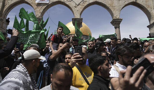 Palestinians chant slogans and wave Hamas flags after Friday prayers during the Muslim holy month of Ramadan, hours after Israeli police clashed with protesters at the Al Aqsa Mosque compound, in Jerusalem's Old City, Friday, April 22, 2022. (AP Photo/Mahmoud Illean)