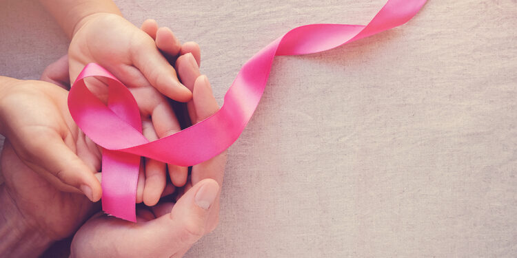 Adult and child hands holding pink ribbons, Breast cancer awareness, abdominal cancer awareness and October Pink day panoramic background , world cancer day