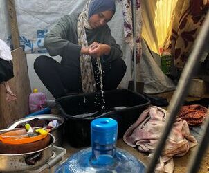 تغسل الملابس بأجر قليل ..طفلة غزية نازحة تكافح لإعالة أسرتها