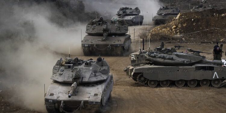 Israeli army tanks manoeuvre in a staging area in northern Israel near the Israel-Lebanon border, Tuesday, Oct. 1, 2024. (AP Photo/Baz Ratner)